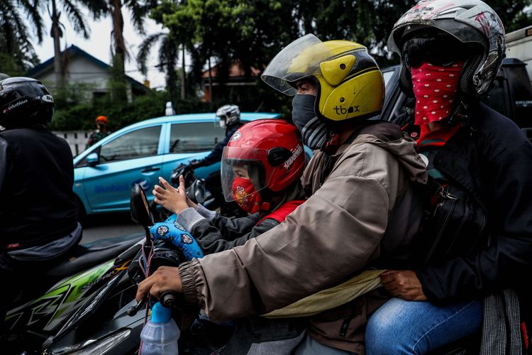 Warga menggunakan masker saat mengendarai sepeda motor melewati pos imbauan penerapan Pembatasan Sosial Berskala Besar (PSBB) di jalan Penjernihan, Tanah Abang, Jakarta Pusat, Senin (13/4/2020). Imbauan ini dilakukan agar masyarakat menerapkan pembatasan sosial berskala besar (PSBB) selama 14 hari, yang salah satu aturannya adalah pembatasan penumpang kendaraan serta anjuran untuk menggunakan masker jika berkendara.