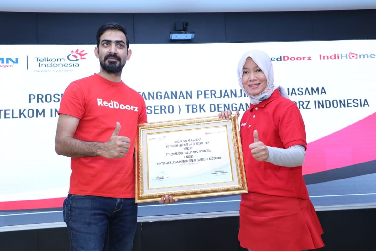 Direktur Consumer Service Telkom Siti Choiriana (kanan) bersama President Direktur RedDoorz Indonesia Mohit Gandas (kiri) usai penandatanganan kerja sama dalam penyediaan layanan IndiHome dan infrastruktur Local Area Network (LAN) di seluruh jaringan mitra penginapan dan hotel yang berafiliasi dengan RedDoorz, di Jakarta, Rabu (25/9/2019).