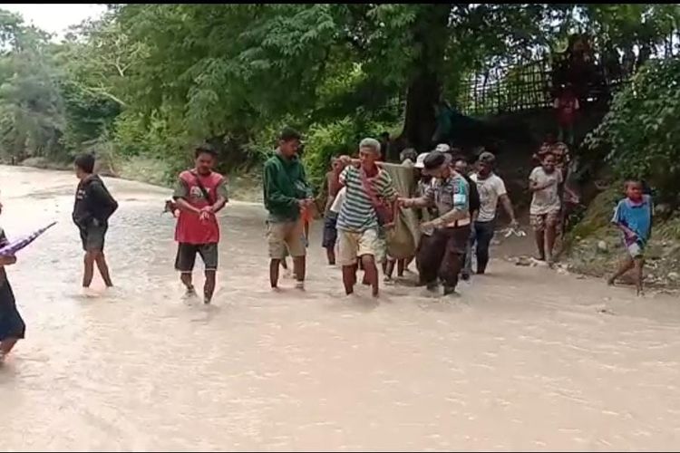 Warga Desa Batnun, Kecamatan Amanuban Selatan, Kabupaten Timor Tengah Selatan (TTS), bersama aparat kepolisian setempat, menggotong jenazah Alexander Manao (75), sejauh 2,5 kilometer menyeberang sungai
