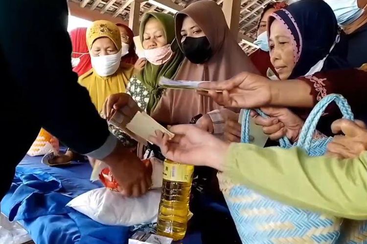 BELI SEMBAKO—Ibu-ibu rumah tangga di Desa Mojorejo, Kecamatan Kebonsari, Kabupaten Madiun, Jawa Timur berebut membeli sembako murah yang dijual Dinas Perdagangan Koperasi dan Usaha Mikro Kabupaten Madiun, Kamis (29/9/2022).