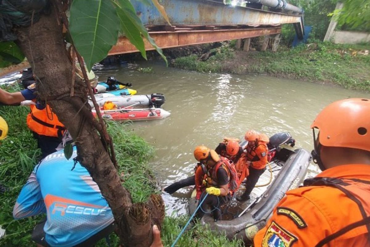 Petugas dari tim SAR dan unsur lainnya saat mengevakuasi tubuh MDS (13) di aliran Kali Cakung, Jakarta Timur, Jumat (9/12/2022). MDS dinyatakan hilang setelah dirinya bermain dan berenang di aliran air tersebut pada Kamis (8/12/2022) kemarin.