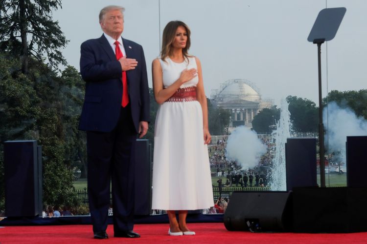 Presiden Amerika Serikat (AS) Donald Trump dan Ibu Negara Melania menempatkan tangan kanan mereka di dada saat lagu kebangsaan AS dikumandangkan, dengan artileri militer melakukan tembakan kehormatan di Jefferson Memorial untuk memperingati Hari Kemerdekaan AS, 4 Juli 2020.