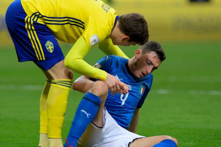 Matteo Darmian dibantu berdiri oleh rekan satu timnya di Manchester United, Victor Lindelof, pada play-off Piala Dunia 2018 antara timnas Italia dan Swedia di San Siro, Senin (13/11/2017).