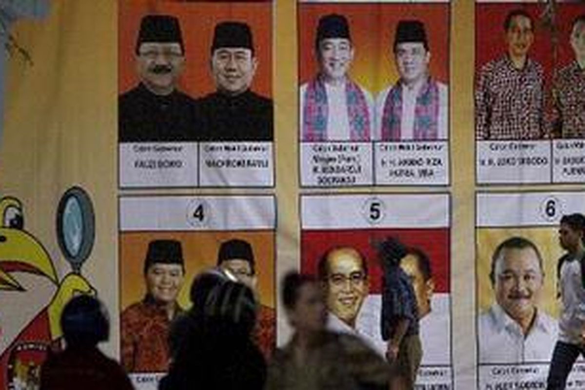 Warga melintas di depan baliho KPU DKI Jakarta yang bergambar enam pasang calon gubernur/wakil gubernur yang akan bertarung dalam Pilkada DKI Jakarta 11 Juli mendatang di Tebet, Jakarta Selatan, Jumat (6/7/2012). Komisi Pemilihan Umum DKI Jakarta memastikan tidak mengadakan penghitungan perolehan suara secara elektronik (e-counting), sebagai pembanding data. Penghitungan suara hanya akan dilakukan secara manual, berjenjang mulai dari tempat pemungutan suara hingga KPU provinsi.