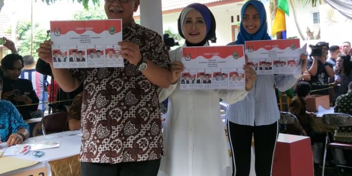 Calon gubernur Jawa Barat Deddy Mizwar memamerkan surat suara sebelum mencoblos bersama istri dan anaknya di TPS 61, Kelurahan Jatiwaringin, Kecamatan Pondok Gede, Bekasi, Rabu (27/6/2018).