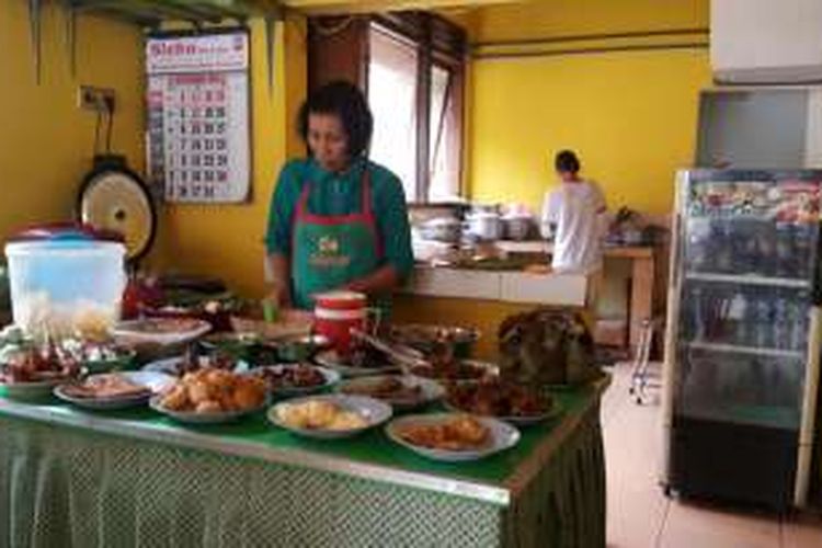 Ibu Yayuk, salah satu pegawai Depot Nasi Pecel 99 milik Karyono di Jalan Cokroaminoto No 99, Kota Madiun, Jawa Timur, sedang melayani pelanggannya.