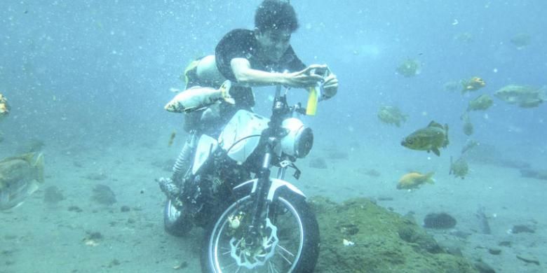 Wisatawan berfoto dengan sepeda motor yang sengaja diparkir sebagai tambahan obyek foto di dasar obyek wisata Umbul Ponggok di Desa Polanharjo, Kabupaten Klaten, Jawa Tengah, Minggu (14/8/2016).