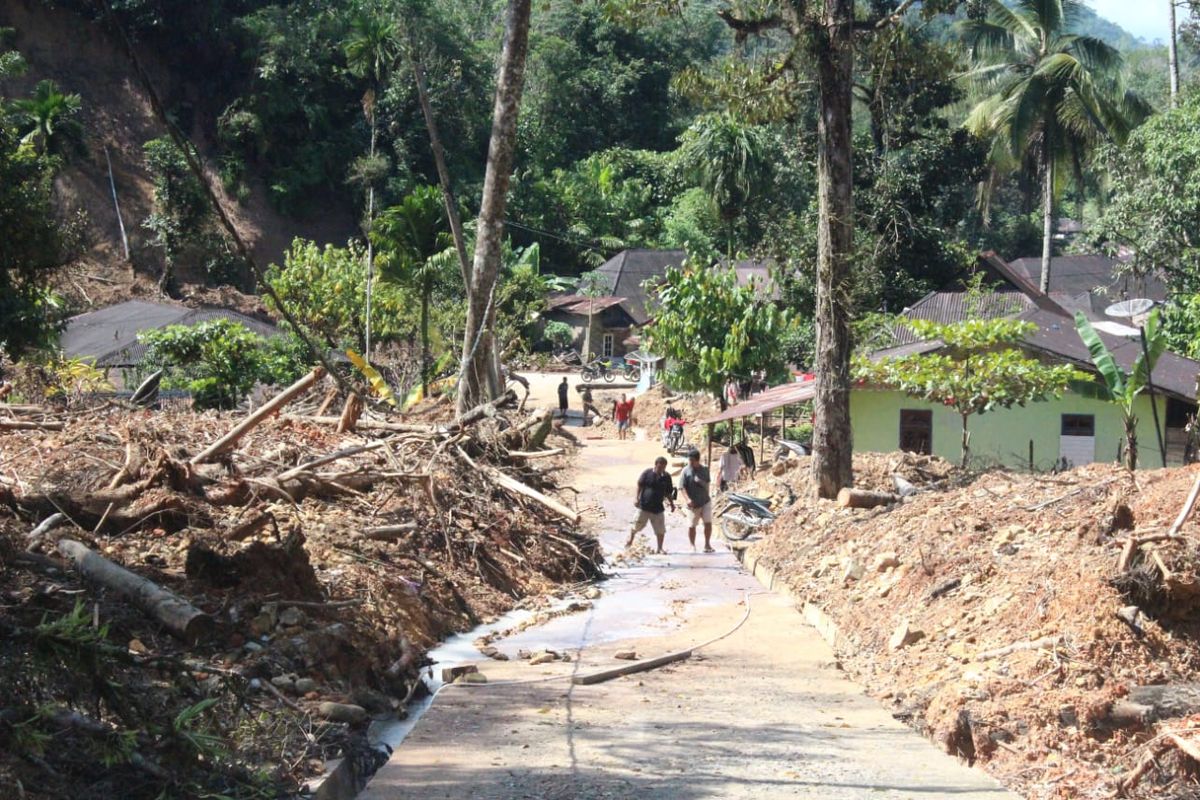 Proses pembersihan jalan dari material batu, kayu usai banjir dan longsor melanda permukiman warga di Pagaran Lumbung I, Kecamatan Adian Koting, Kabupaten Tapanuli Utara, Selasa (25/11/2025).