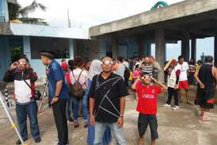 Sejumlah warga Kota Kupang, Nusa Tenggara Timur (NTT) sedang menyaksikan gerhana matahari di di kompleks Masjid Nurul Hidayah Kelapa Lima, Kota Kupang, meski cuaca dalam keadaaan mendung, Rabu (9/3/2016).