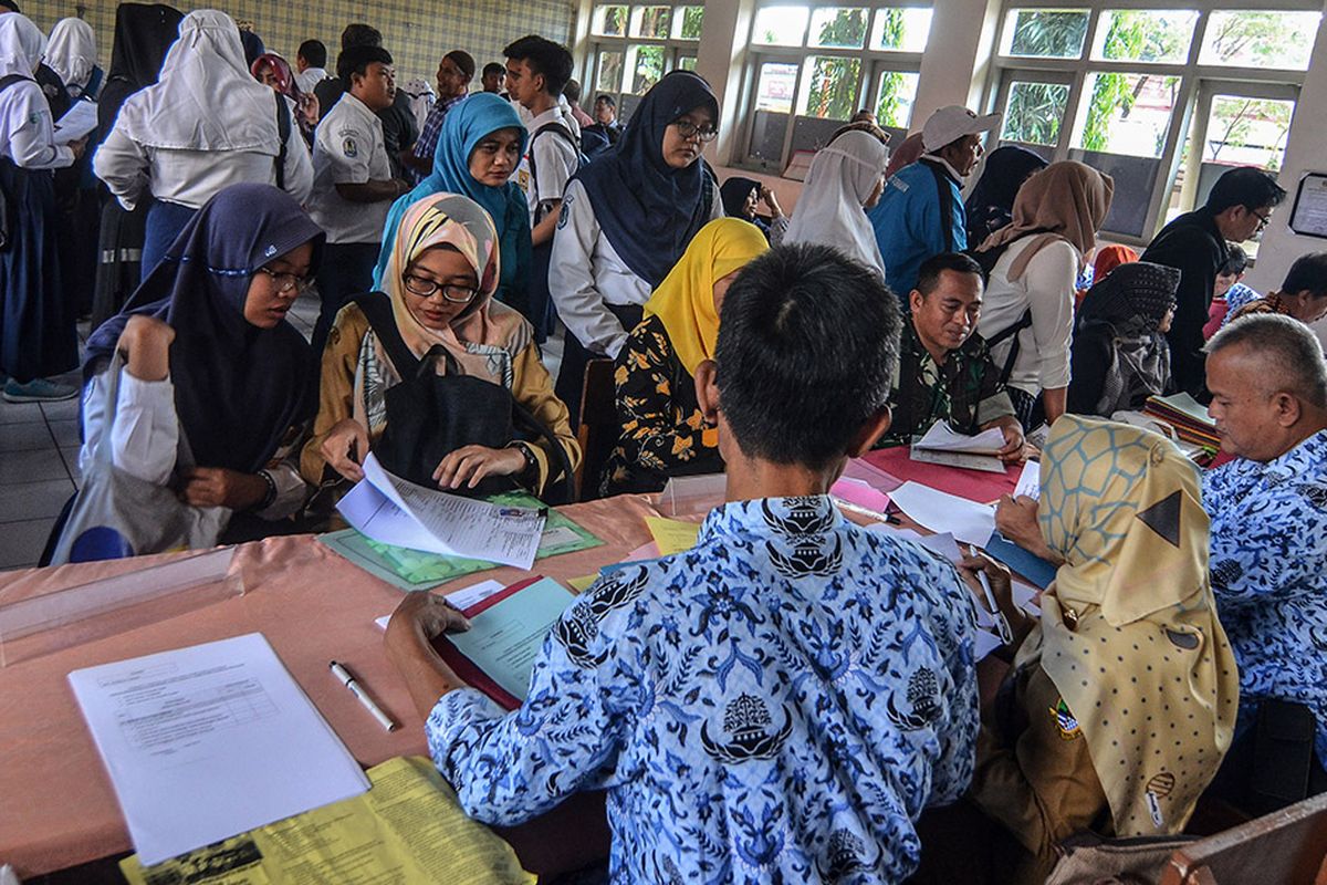 Antrean siswa dengan orangtua murid mengikuti seleksi Penerimaan Peserta Didik Baru (PPDB) di SMAN 2 Kota Tasikmalaya, Jawa Barat, Senin (17/6/2019). Kementerian Pendidikan dan Kebudayaan (Kemendikbud) menerapkan sistem PPDB dengan mekanisme berdasarkan sistem jalur zonasi atau pemetaan wilayah sebanyak 90 persen, jalur prestasi lima persen, dan jalur perpindahan orang tua wali paling banyak lima persen, bertujuan untuk pemerataan hak memperoleh pendidikan bagi anak-anak usia sekolah.