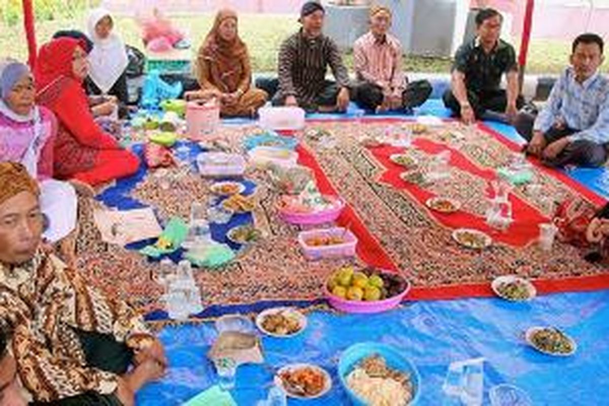 Warga etnis Jawa yang tinggal di Kota Sawahlunto, Sumatera Barat, memotong tumpeng pada tradisi Makan Bajamba, Senin (1/12/2014). Tradisi itu merupakan puncak perayaan hari jadi Kota Sawahlunto yang tahun ini memasuki usia ke-126. Adanya etnis Jawa di Kota Sawahlunto tidak terlepas dari sejarah tambang batubara yang berjaya sejak tahun 1888 hingga 1988. Saat itu, Pemerintah Kolonial Belanda banyak mendatangkan warga etnis Jawa sebagai pekerja di tambang batubara. 