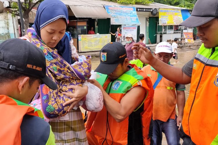 Seorang ibu yang juga warga Puri Indah, Jakarta Barat, datang ke Fave Hotel, Kembangan Selatan dengan menggunakan bantuan getek atau perahu dari UPK Badan Air Lingkungan Hidup, Kamis (2/1/2020) siang. Dia diungsikan dari lokasi banjir setelah beberapa saat melahirkan.