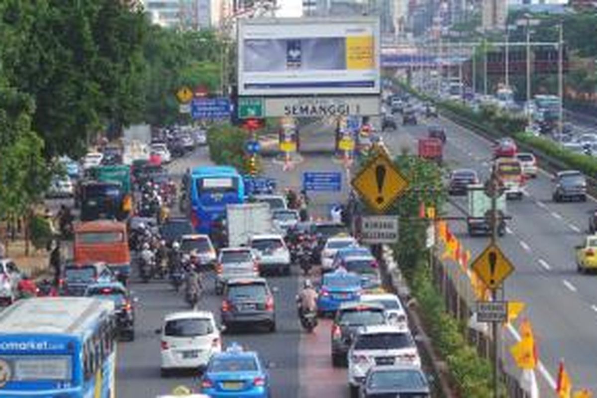 Kondisi lalu lintas di Jalan Jenderal Gatot Subroto dekat Gerbang Tol Semanggi 1, Senin (16/12/2013). Polisi memberlakukan sistem buka-tutup pada gerbang tol itu untuk mengatur kepadatan lalu lintas di jalur arteri maupun dalam tol.