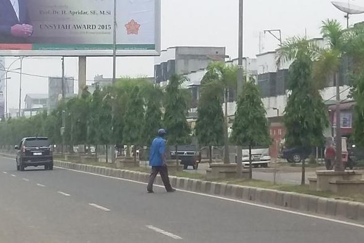 Sejumlah warga melintas di lintas Jalan Medan-Banda Aceh Kota Lhokseumawe Sabtu (24/10/2015). Kabut asap kembali melanda kota tersebut sejak dua hari terakhir dan mengakibatkan penerbangan Medan-Aceh Utara lumpuh total