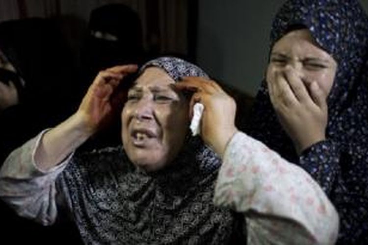 Dua pelayat menangis dalam pemakaman Rahaf Hassan, 2 tahun, dan ibunya yang sedang hamil, Noor Hassan. Keduanya tewas akibat serangan udara Israel pada Minggu (11/10/2015) pagi. 