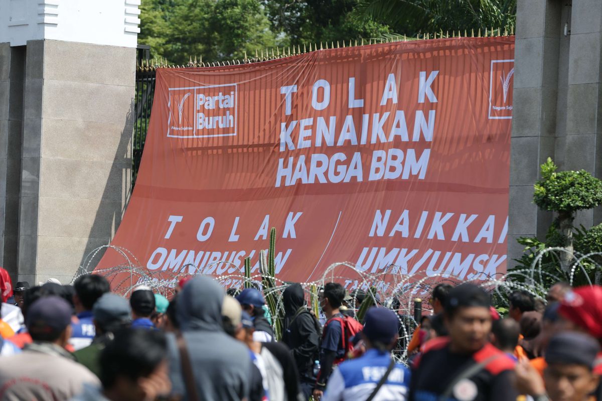 Massa dari elemen buruh melakukan demonstrasi di depan Gedung DPR/MPR RI, Jakarta, Selasa (6/9/2022). Mereka memasang spanduk berukuran besar hingga menutupi gerbang masuk utama kompleks parlemen untuk menolak kenaikan harga BBM.