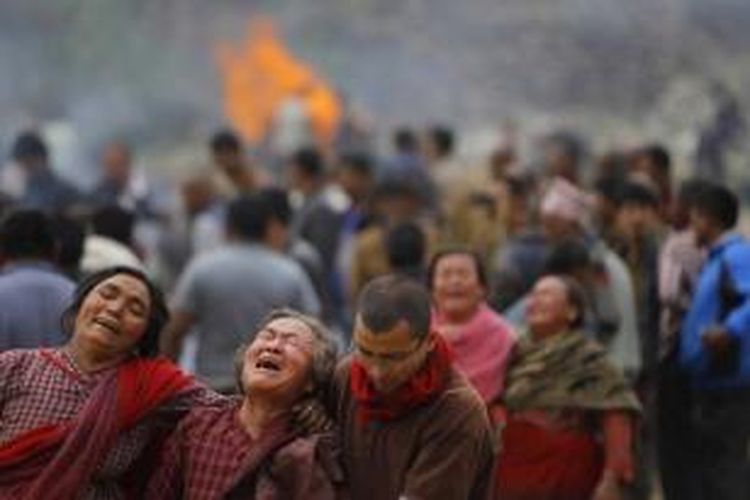 Warga menangis saat kremasi massal korban gempa di Bhaktapur, dekat Kathmandu, Nepal, 26 April 2015. Gempa tektonik berkekuatan 7.9 SR mengguncang Nepal pada 25 April, mengakibatkan ribuan orang meninggal.