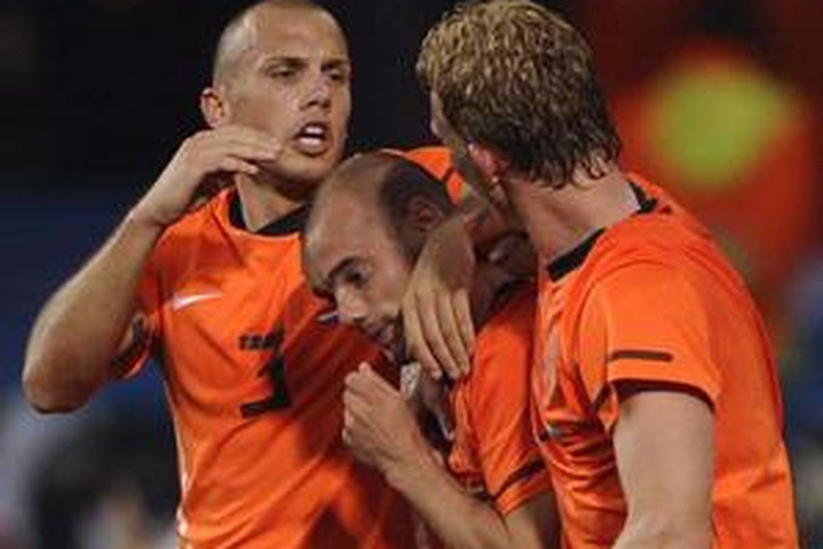 Gelandang Belanda, Wesley Sneijder (tengah), mendapat sambutan dari John Heitinga (kiri) dan Dir Kuyt. Sneijder jadi penentu kemenangan Belanda atas Brasil dengan skor 2-1 di perempat final Piala Dunia 2010, Jumat (2/7/10).