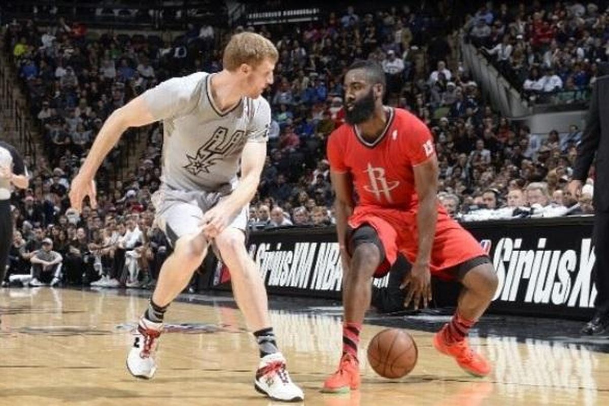 Pemain Houston Rockets, James Harden (kanan) mendribble bola di bawah penjagaan San Antonio Spurs, pada pertandingan lanjutan NBA 2013-2014, di AT&T Center, San Antonio, Rabu (25/12/2013).