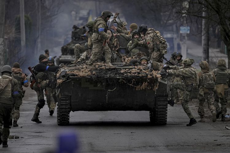 Tentara Ukraina menaiki kendaraan tempur di luar Kyiv, Sabtu (2/4/2022), dalam lanjutan perang melawan Rusia.