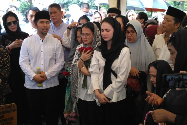 Arumi Bachsin (tengah) didampingi suaminya Emil Dardak (kiri) mengantarkan jenazah ayahanda Aries Aliruddin Bachsin, di TPU Kebon Nanas, Jakarta Timur, Jumat (26/10/2018). 