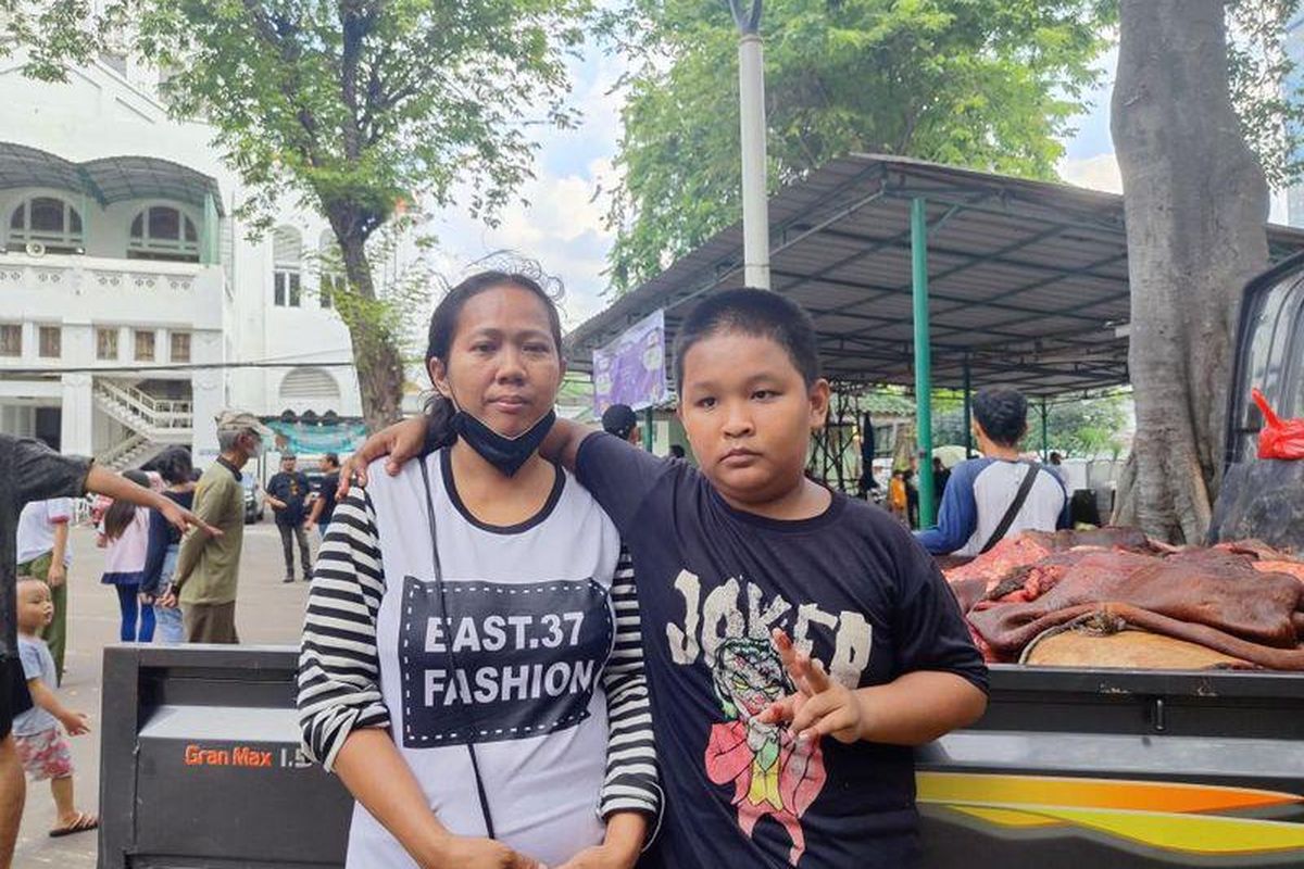 Siti dan anaknya jauh-jauh dari Jakarta Timur untuk menanti pembagian daging kurban di Masjid Cut Meutia, Jakarta Pusat, Kamis (29/6/2023)