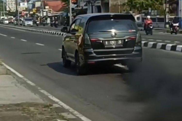 Innova diesel sedang ngebut mengelurkan asap knalpot berwarna hitam pekat seperti cumi-cumi.