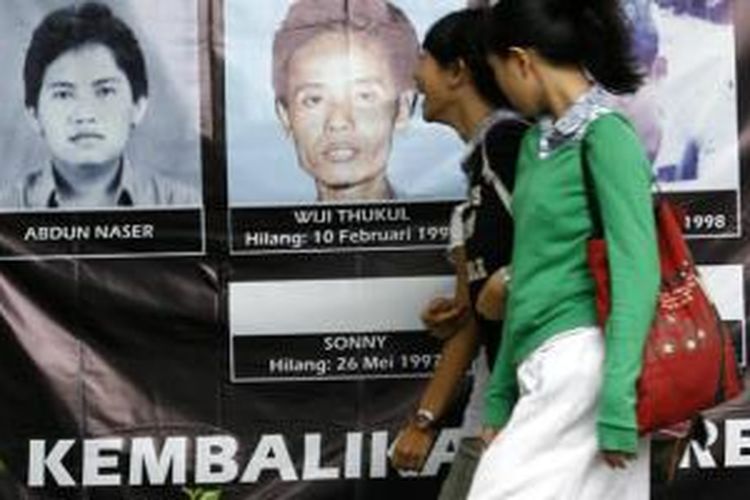 Pejalan kaki melintas di depan baliho bergambar foto-foto orang hilang lengkap dengan nama dan tanggal hilangnya mereka, di Jalan Diponegoro, Jakarta, Sabtu (8/11/2008). 