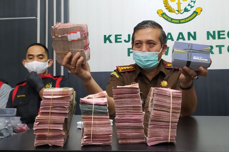 Kajari Purwokerto Sunarwan menunjukkan barang bukti uang diduga hasil korupsi dana jaring pengaman sosial Covid-19 sebanyak Rp 470 juta di Kantor Kejari Purwokerto, Kabupaten Banyumas, Jawa Tengah, Selasa (9/3/2021) malam.