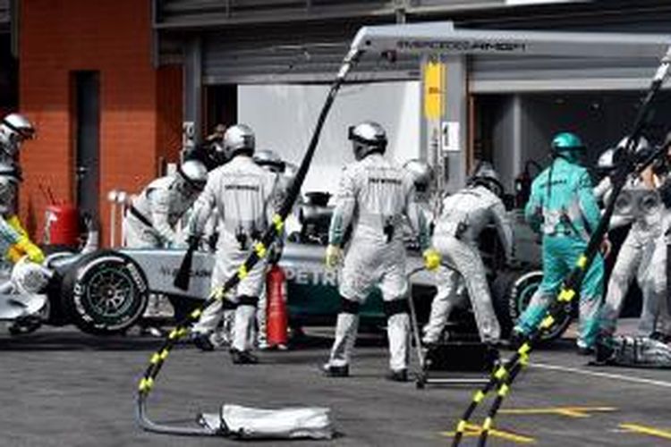 Mekanik tim Mercedes mendorong mobil Lewis Hamilton masuk garasi setelah berhenti dari balapan GP Belgia di Sirkuit Spa-Francorchamps, Minggu (24/8/2014).