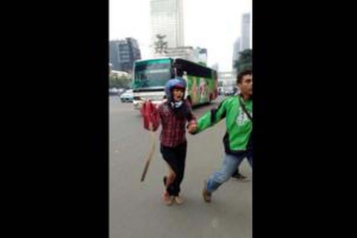 Foto pengemudi gojek yang tampak tengah menuntun seorang wanita yang terluka di bagian kakinya saat peristiwa ledakan bom Sarinah, Kamis (14/1/2016), ramai diperbincangkan di media sosial.