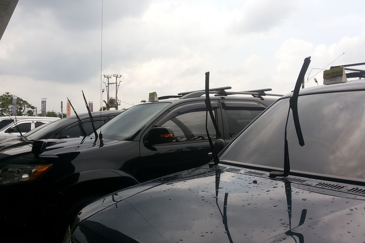 Deretan mobil yang parkir di area terbuka dengan posisi wiper diangkat.