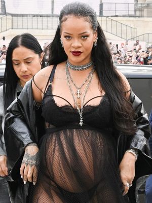 Rihanna tiba di fashion show Dior dengan memakai lingerie hitam sembari memamerkan baby bump-nya.