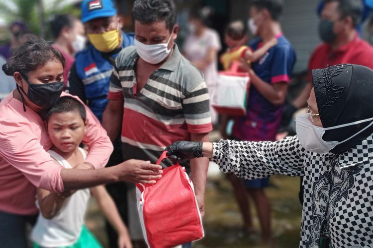 Menteri Sosial Republik Indonesia, Tri Rismaharini, saat memberikan bantuan kepada korban banjir di Dukuh Dempel Desa Kalisari Kecamatan Sayung Kabupaten Demak Jawa Tengah yang sudah sepekan ini terendam banjir, Jumat (12/2/2021).