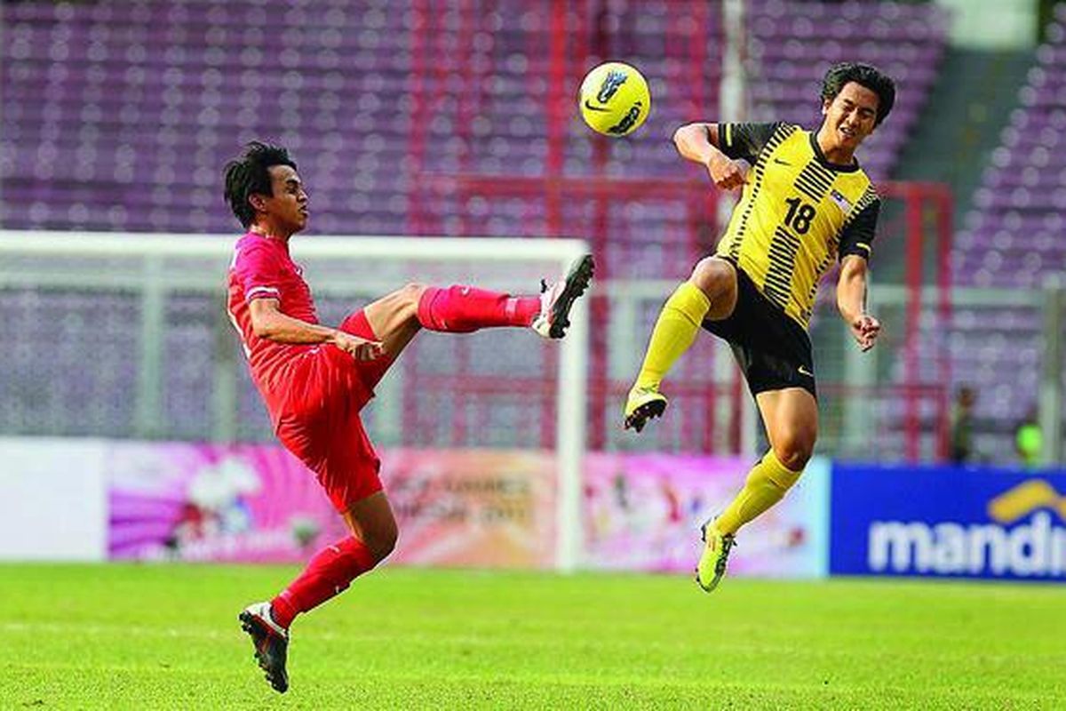 Pemain Singapura, Shahdan Bin Sulaiman (kiri), berebut bola dengan pemain Malaysia, Ibrahim Syahrul Azwari,  di Stadion Utama Gelora Bung Karno, Jakarta, Senin (7/11). Malaysia akan menghadapi Thailand, Rabu (9/11) pukul 16.00.