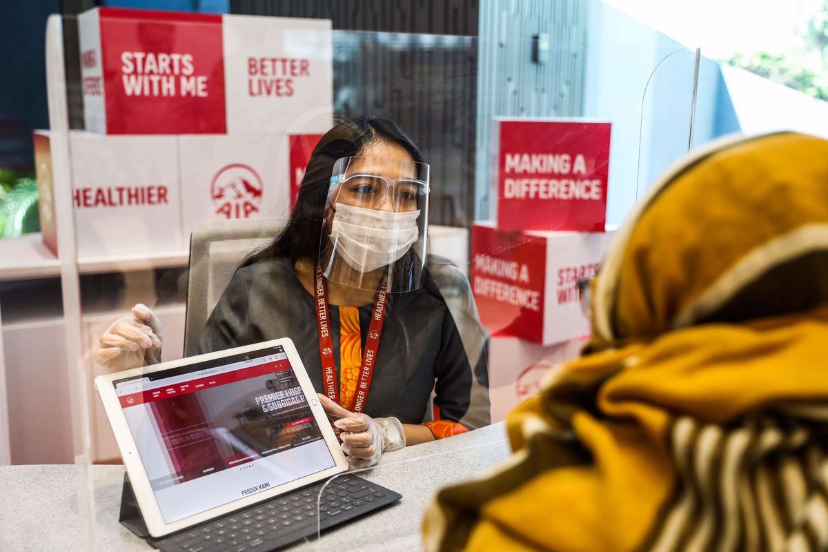 Petugas Customer Service PT AIA FINANCIAL (AIA) menggunakan masker dan pelindung wajah saat melayani nasabah di Customer Service Center, AIA Central, Jakarta Pusat, Rabu (17/6/2020). Memasuki fase kenormalan baru (new normal) layanan Customer Service Center AIA kembali beroperasi melayani nasabah dengan menerapkan protokol kesehatan yang dianjurkan pemerintah dan perusahaan.