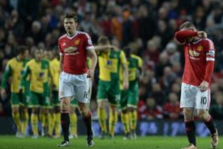 Reaksi Michael Carrick (kiri) dan Wayne Rooney saat Norwich City mencetak gol ke gawang Manchester United, Sabtu (19/12/2015).