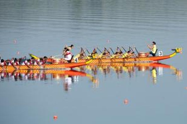 Tim perahu naga Myanmar (depan) dan Indonesia bersaing ketat di nomor 500 meter 10 kru, pada SEA Games 27 Myanmar di  Naypyidaw, Kamis (19/12/2013).