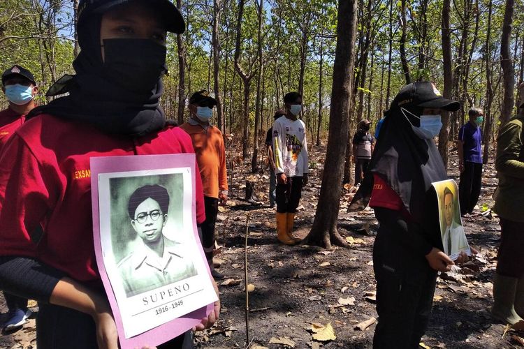 Salah satu peserta upacara bendera di tengah hutan Desa Ngadiboyo Nganjuk membawa foto Soepeno, Selasa (17/8/2021). Soepeno merupakan menteri yang gugur saat bergerilya melawan Belanda di Gunung Wilis wilayah Nganjuk