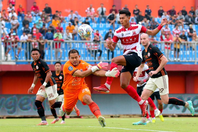Penjaga gawang Persija Jakarta Andritany saat menghalau tendangan pemain Madura united Malik Risaldi saat pertandingan pekan ke-27 Liga 1 2022-2023 yang berakhir dengan skor 0-0 di Stadion Gelora Ratu Pamelingan Pamekasan, Minggu (26/2/2023) sore. 