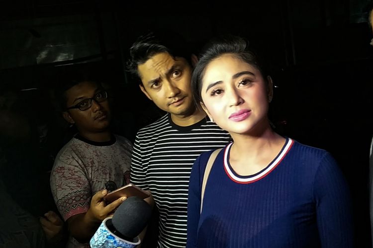 Penyanyi dangdut Dewi Perssik dan sang suami Angga Wijaya saat mendatangi Subdit Ranmor Polda Metro Jaya, Jakarta Selatan, Rabu (10/1/2018).