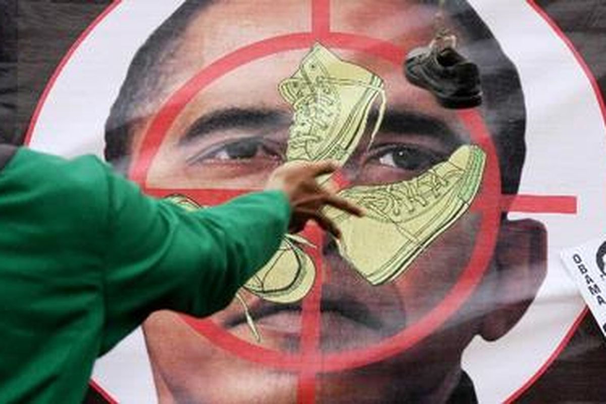Aktivis Badan Koordinasi Lembaga Dakwah Kampus (BKLDK) melempar gambar Presiden Amerika Serikat, Barrack Obama dengan sepatu saat menggelar aksi di depan Gedung Parlemen Senayan, Jakarta Pusat, Jumat (5/3/2010). Mereka secara tegas menolak kedatangan Obama ke Indonesia yang dilakukan 20-22 Maret 2010.
