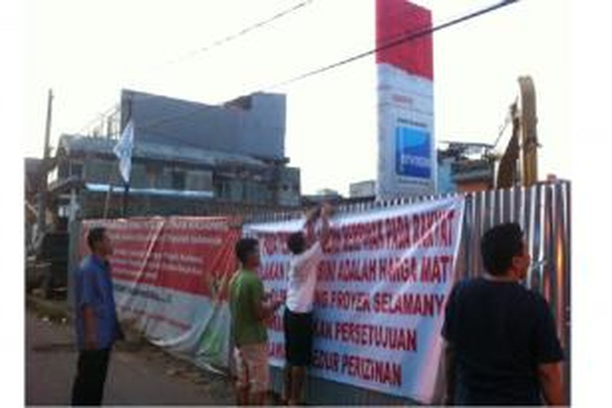 Warga RW 04 Kelurahan Balimester, Jatinegara, Jakarta Timur memasang spanduk sebagai protes pembangunan proyek SPBG yang tetap berjalan meski telah disegel pemerintah. Foto diambil pada Sabtu (14/05/2015).

