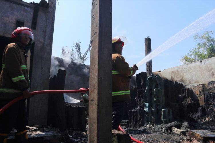 Petugas sedang berupaya memadamkan api yang membakar gudang yang menyimpan barang-barang berbahan plastik dan karet di Dusun Sidomulyo, Desa Pucangro, Kecamatan Gudo, Kabupaten Jombang, Jawa Timur, Selasa (6/6/2023).