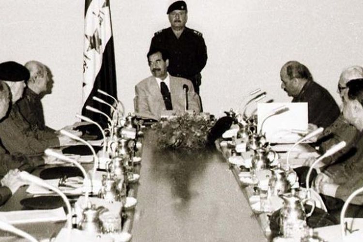 Presiden Irak Saddam Hussein, tengah, memimpin rapat gabungan Dewan Komando Revolusi dan komando regional Partai Baath yang berkuasa pada 31 Oktober 1998.
