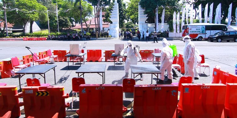 Petugas kesehatan menyemprotkan cairan disinfektan di Tempat Pemungutan Suara saat simulasi Pemilihan Kepala Daerah di Banyuwangi, Jawa Timur, Senin (14/9/2020).  Simulasi tersebut digelar untuk menyiapkan segala hal yang diperlukan untuk penyelenggaraan Pilkada serentak pada 9 Desember 2020 di tengah wabah COVID-19. ANTARA FOTO/Budi Candra Setya/wsj.