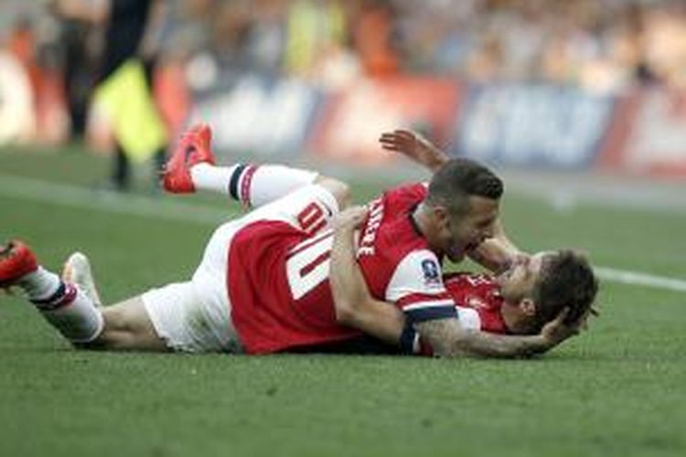Gelandang Arsenal Aaron Ramsey (bawah) merayakan golnya ke gawang Hull City, pada final Piala FA, di Wembley, Sabtu (17/5/2014).