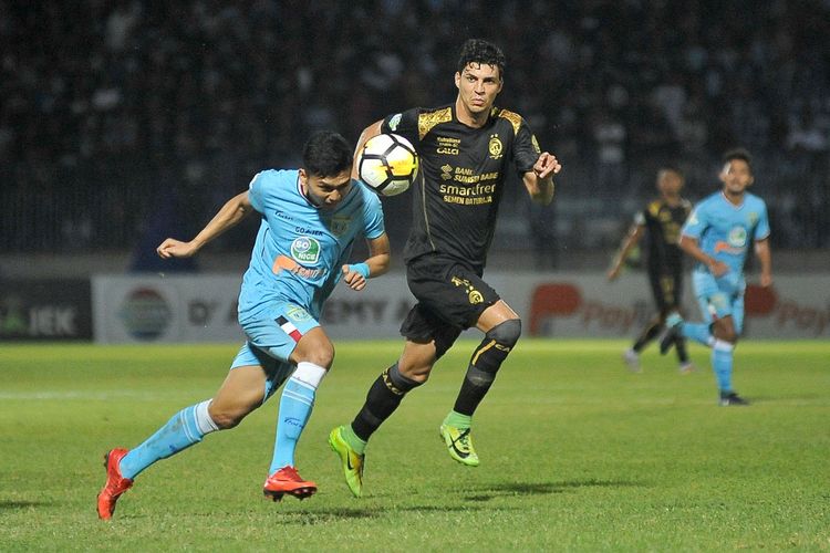 Pesepak bola Persela Lamongan Dendy Sulistyawan (kiri) berusaha melewati hadangan pesepak bola Sriwijaya FC Alan Hendrique Ferreira (kanan) dalam lanjutan Liga 1 Indonesia di Stadion Surajaya Lamongan, Jawa Timur, Jumat (02/11/2018). Persela Lamongan kalahkan Sriwijaya FC dengan skor 3-0.  