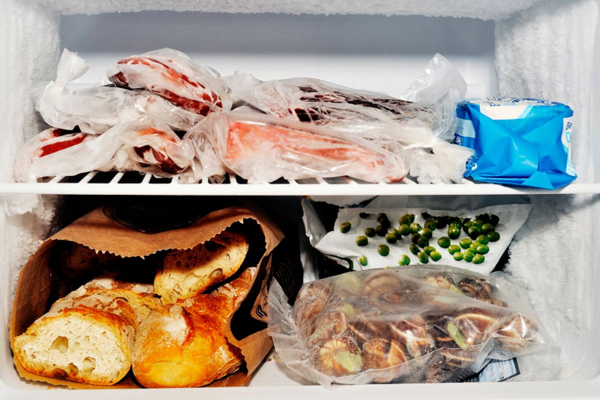 Freezer compartment of a refrigerator containing meat and frozen vegetables as well as bread