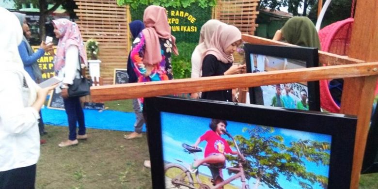 Pengunjung melihat pameran foto dalam Gule Rampo Expo di Lapangan Jenderal Sudirman, Kota Lhokseumawe, Aceh, Rabu (27/12/2017).